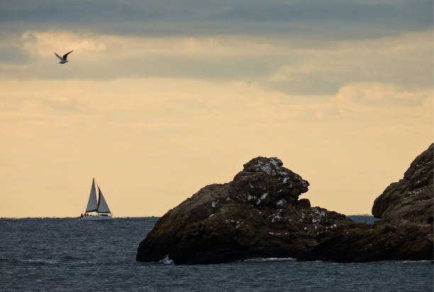 Voilier au large de l'Atlantique sur ciel orangé