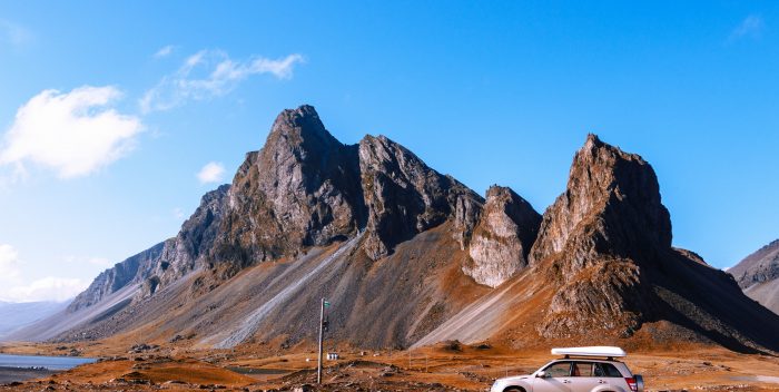 Voiture arrêtée devant une montagne pendant un roadtrip